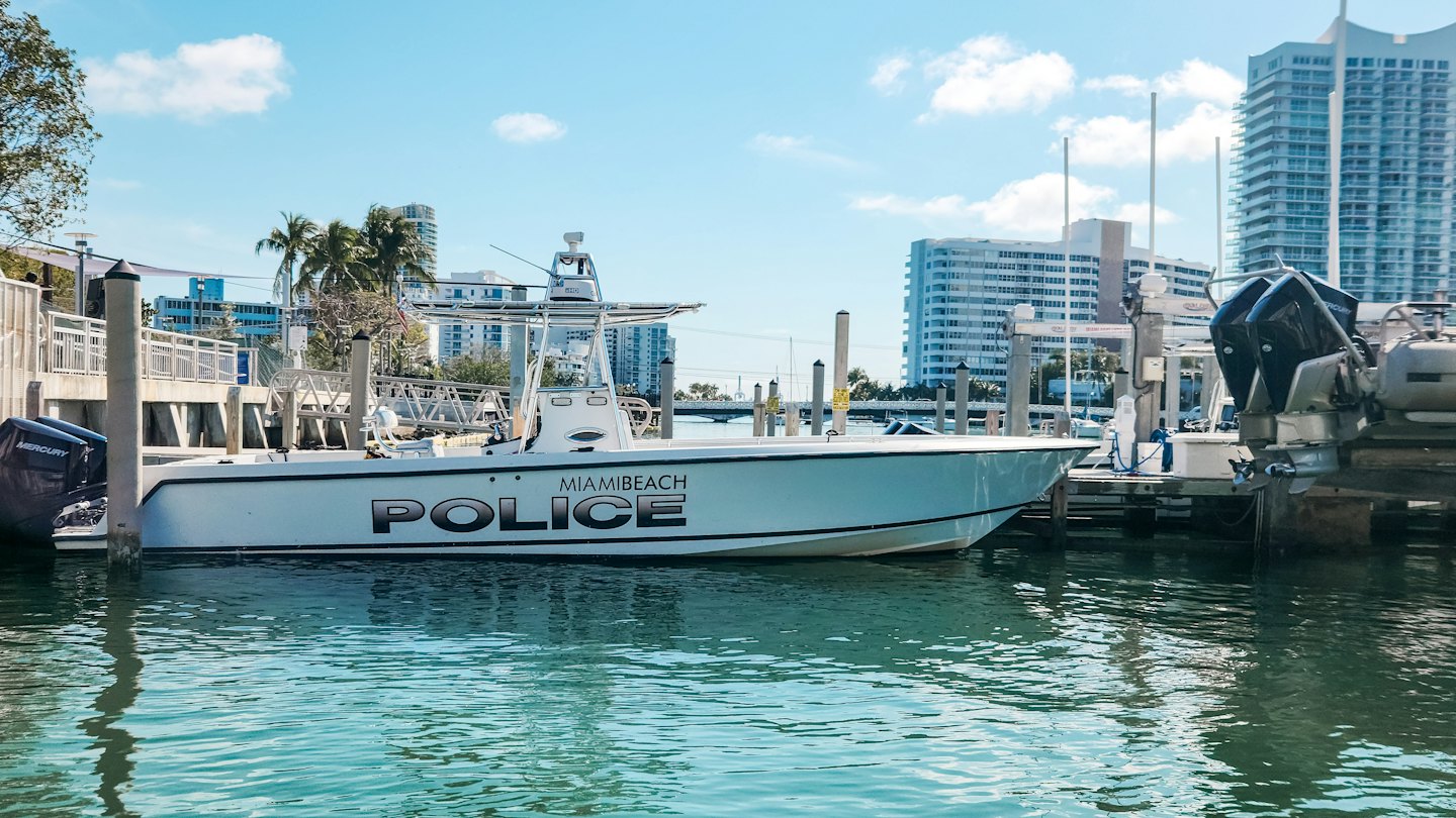 Miami Beach police patrol boat docked at a sunny marina.